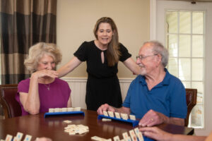 Courtney, the Director of Sales and Marketing at The Manor at York Town, chats with a couple playing a game in the game room.